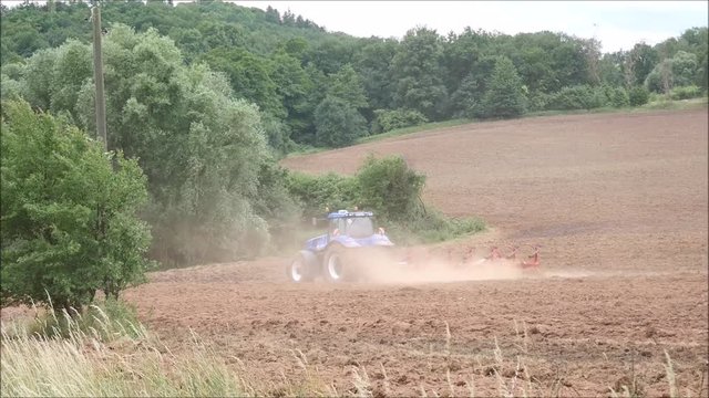 Bauer pfl&uuml;gt sein Feld um mit Traktor