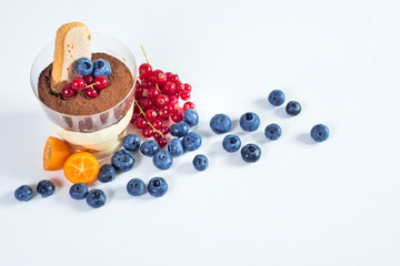 Sweet dessert tiramisu with berries on white background