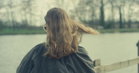 Young woman admiring lake in slow motion