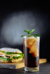 drink cocktail of cola with ice, mint and big sandwich Street food, fast food. Homemade burgers with beef
