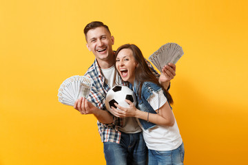 Young win couple, woman man, football fans holding bundle of dollars, cash money, soccer ball,...