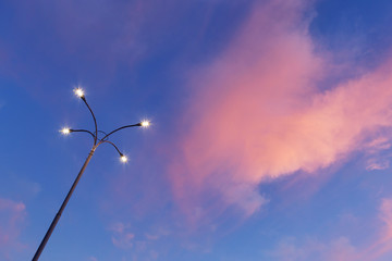 modern street lamp shines against the blue sky and red clouds, sunset, twilight
