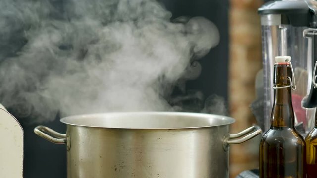 Saucepan with steam. The smoke coming from the metal pan on the stove. 4K