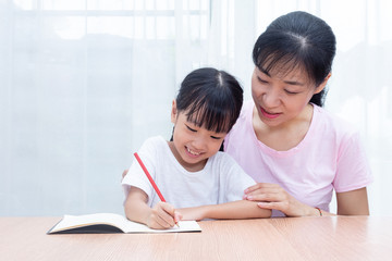Asian Chinese mother teaching daughter doing homework