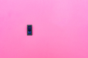 Blue toggle switch on a pink background. Abstract photo with blank empty space for free title
