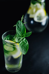 Fresh Summer Drink. Healthy glass detox fizzy water with lemon, mint, rosemary and cucumber in mason jar over dark background. Healthy food concept. Detox diet.