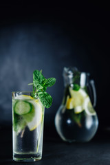 Fresh Summer Drink. Healthy glass detox fizzy water with lemon, mint, rosemary and cucumber in mason jar over dark background. Healthy food concept. Detox diet.
