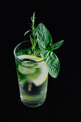 Fresh Summer Drink. Healthy glass detox fizzy water with lemon, mint, rosemary and cucumber in mason jar over dark background. Healthy food concept. Detox diet.