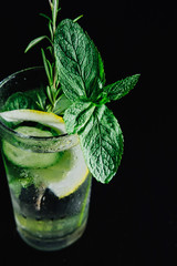 Fresh Summer Drink. Healthy glass detox fizzy water with lemon, mint, rosemary and cucumber in mason jar over dark background. Healthy food concept. Detox diet.