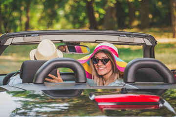 Young couple driving in their cabriolet car. Summer vacation and travel concepts.