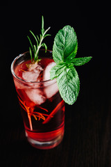 pink cocktail with mint and rosemary on black background close-up  view from above