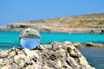 tropical view with glass ball on stones