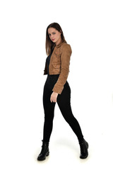 full length portrait of brunette girl wearing brown leather jacket.   standing pose on white...
