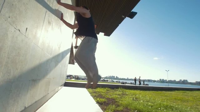 Young man performing an extremal flip through the threshold at summer day