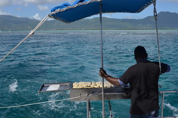Cuisinier faisant griller des aliments à l'arrière d'un bateau au large, Océan Indien