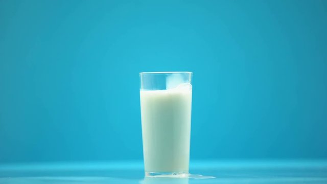 Hand pouring milk in glass on table, healthy nutrition, dairy product, breakfast