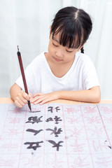Asian little Chinese girl practice Chinese calligraphy