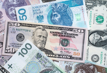 Polish zloty and US dollar banknotes mixed, flat lay view. Zloty dollar exchange rate.