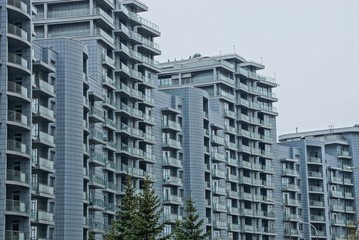 Fototapeta premium a row of gray houses with balconies and windows against the sky