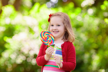 Little girl with colorful candy lollipop