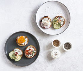 Toasts with mashed avocado and cucumber on white plate. Top view. Healthy eating, dieting, cleansing concept