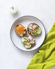 Toasts with mashed avocado and cucumber on white plate. Top view. Healthy eating, dieting, cleansing concept