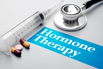 Hormone Therapy, medical concept. Syringe, pills and stethoscope on grey background. Selective focus image.