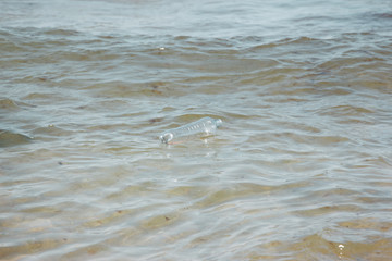 Plastic bottle in ocean water, littering the sea concept image