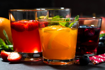 fresh fruit lemonades in assortment on dark table, closeup