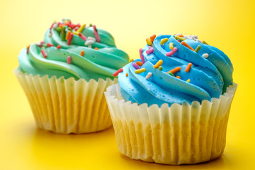 Tasty cupcakes on yellow background, selective focus
