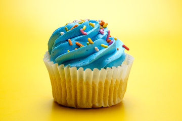 Tasty cupcakes on yellow background, selective focus