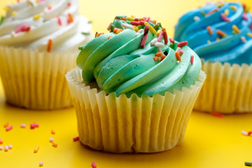 Tasty cupcakes on yellow background, selective focus
