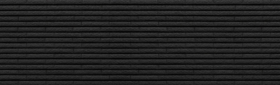 Panorama of Black stone brick tile wall pattern and background