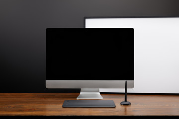 close up view of designer workplace with blank computer screen and graphic tablet on wooden tabletop