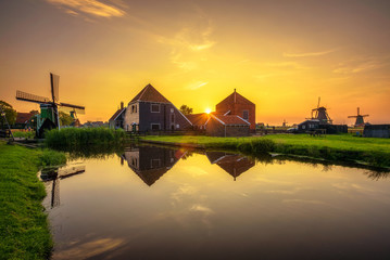 Sunset above farm houses and windmills of Zaanse Schans in the Netherlands