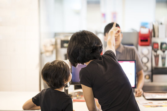 Mother And Child Ordering Meals In The Restaurant