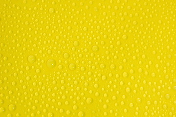 natural water drops on yellow background texture