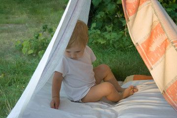 Smeared children play in nature in an improvised house. Homemade tent, hut, for fun girls and boys. Camping © SVIATLANA