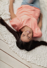 top view.young woman lying on white carpet in living room