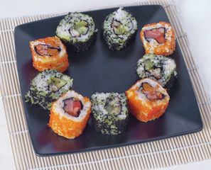 Sushi Set - different types of Maki sushi and chopsticks on a b