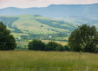 Fototapeta na wymiar Beautiful view on small village in Ukraine. Small village in hills.Summer mountain landscape