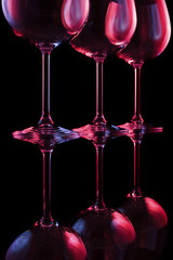 Party wine glasses in nightclub lit by red, blue, lilac lights, nightlife and entertainment...