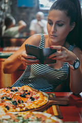 Woman taking picture of her food in the restaurant