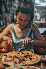 Girl eating pizza at the restaurant