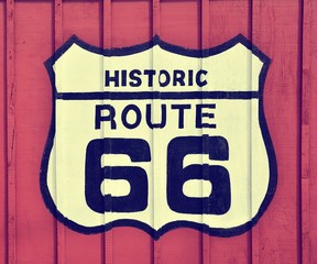 Route 66 sign with wooden background.