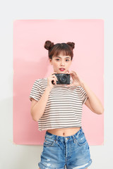 Smiling girl holding digital camera on white background