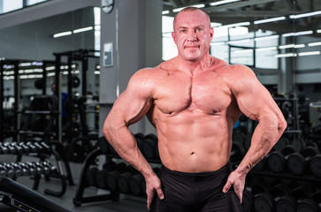 Obraz na płótnie Canvas Muscular bodybuilder guy in gym