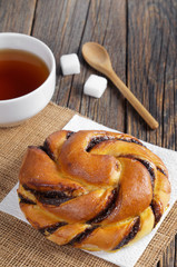 Bun with chocolate and cup of tea