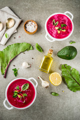 Vegan food, summer cold Beetroot gazpacho soup with lemon, avocado and fresh herbs copy space top view