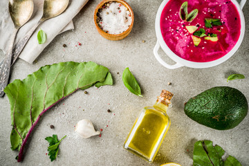 Vegan food, summer cold Beetroot gazpacho soup with lemon, avocado and fresh herbs copy space top view
